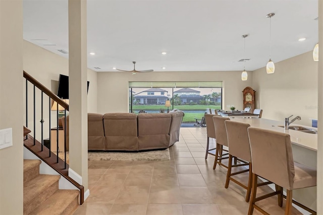 tiled living room featuring ceiling fan and sink