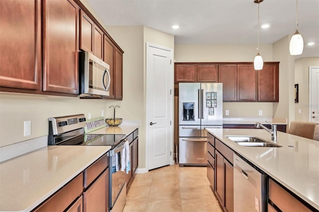 kitchen with sink, light tile patterned floors, stainless steel appliances, and pendant lighting