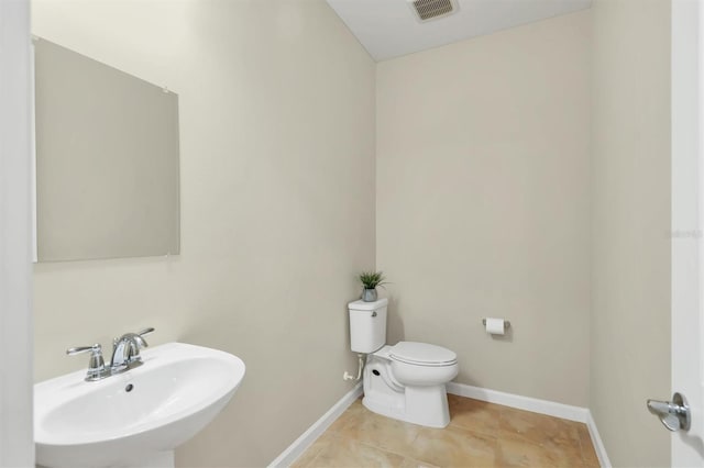 bathroom with sink, toilet, and tile patterned flooring