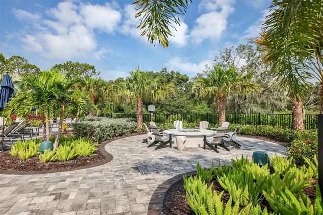 view of community featuring a patio and an outdoor fire pit