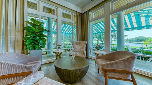 7217 Churston Ln, University Park, FL 34201 - sunroom featuring plenty of natural light, ornamental molding, wood finished floors, and a water view