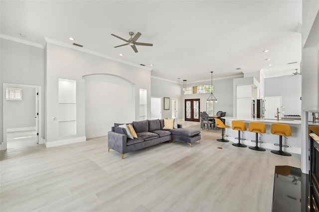 living room featuring ceiling fan, light wood-type flooring, and ornamental molding