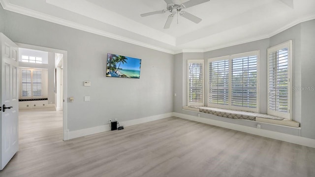 unfurnished room featuring light wood-type flooring, a raised ceiling, and ceiling fan