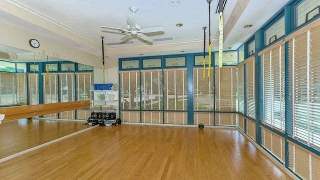 exercise room with hardwood / wood-style flooring, ceiling fan, and ornamental molding