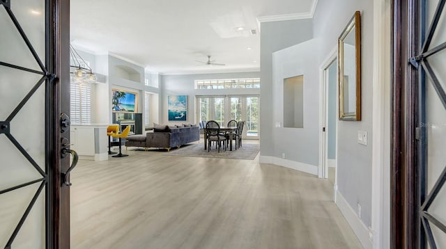 entrance foyer with crown molding, ceiling fan, and light hardwood / wood-style flooring