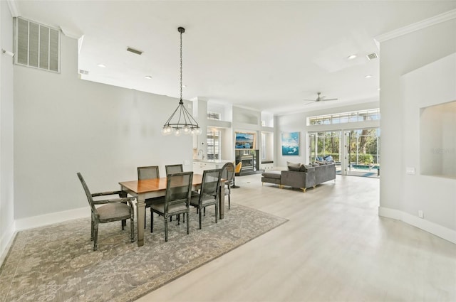 dining space with ceiling fan with notable chandelier and light wood-type flooring