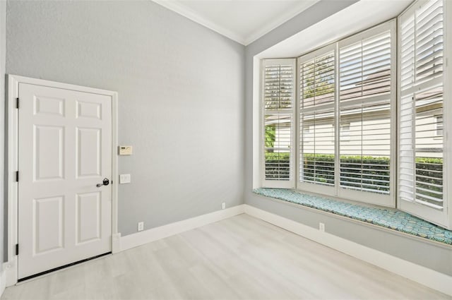 empty room with crown molding and light wood-type flooring