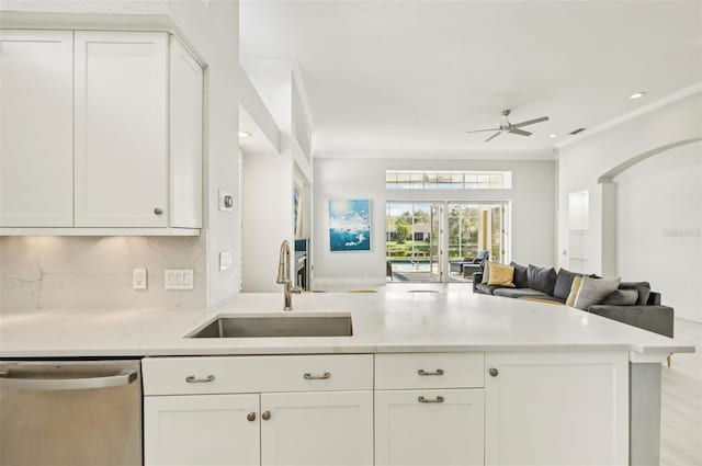 kitchen with sink, ornamental molding, white cabinets, stainless steel dishwasher, and kitchen peninsula