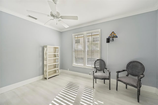 sitting room with ornamental molding, ceiling fan, and light wood-type flooring