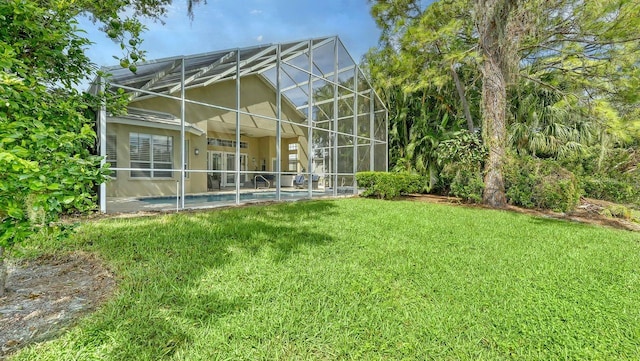 back of house featuring a lawn and glass enclosure