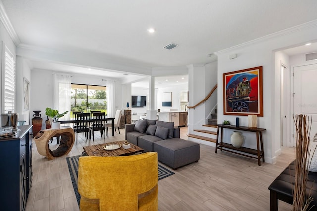 living room with crown molding and light hardwood / wood-style floors