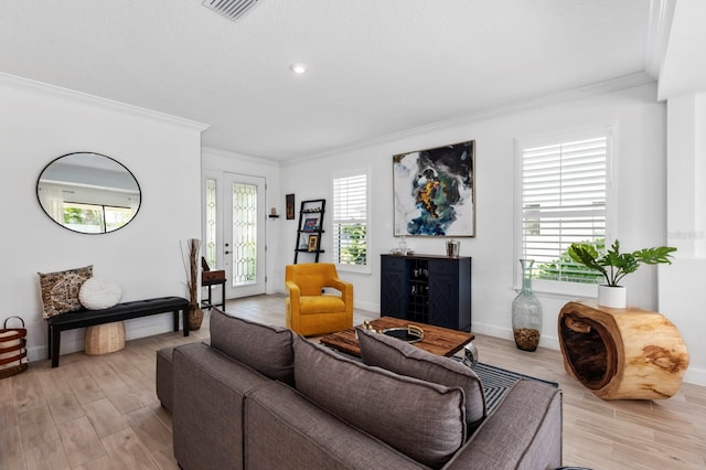 living room with ornamental molding and light hardwood / wood-style floors