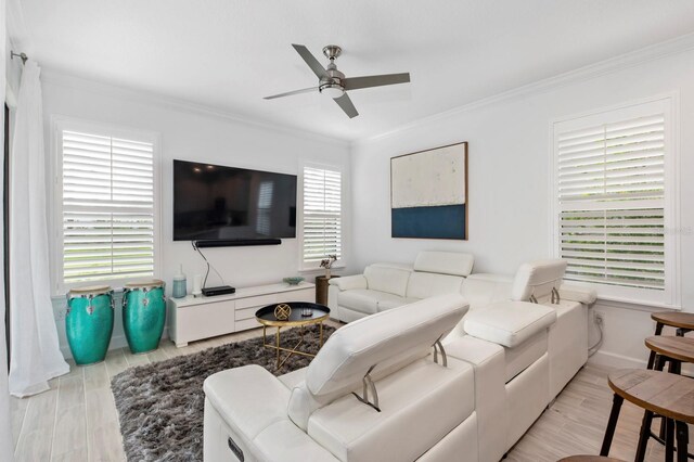 living room featuring ceiling fan, ornamental molding, and light hardwood / wood-style floors