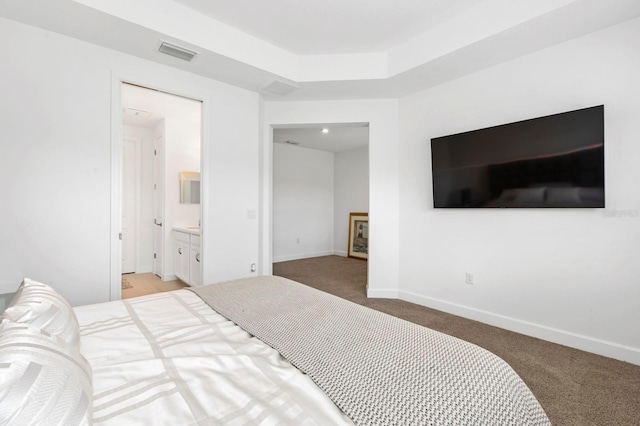 bedroom featuring ensuite bathroom and light colored carpet