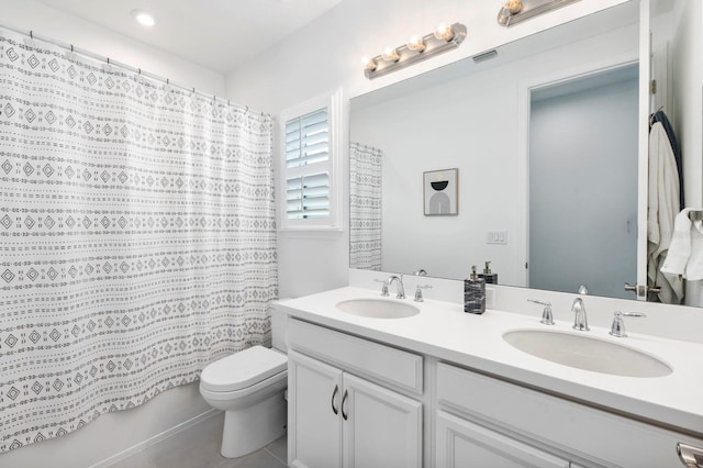 bathroom featuring toilet, dual bowl vanity, and tile patterned flooring