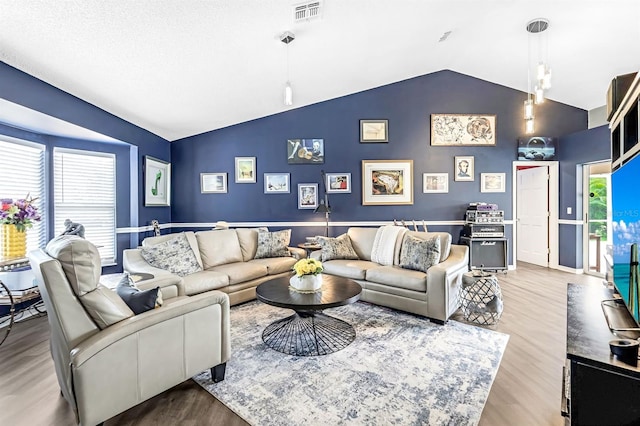 living room featuring vaulted ceiling and light wood-type flooring