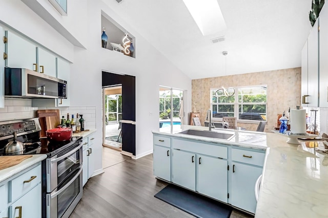 kitchen featuring hanging light fixtures, a healthy amount of sunlight, hardwood / wood-style floors, and stainless steel appliances