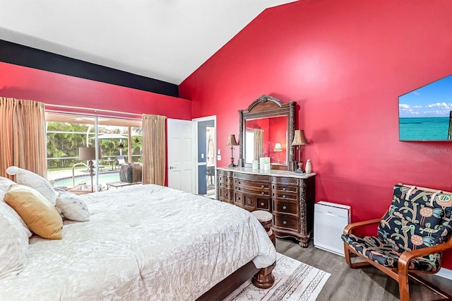 bedroom featuring high vaulted ceiling, access to exterior, and hardwood / wood-style flooring