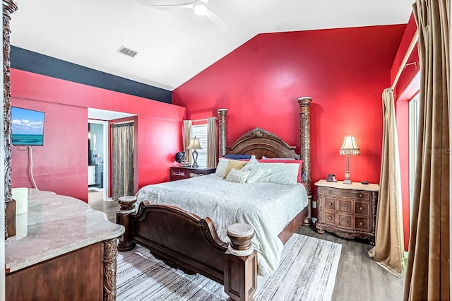 bedroom with ceiling fan, vaulted ceiling, light wood-type flooring, and multiple windows