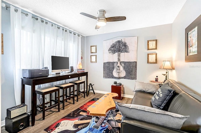 living room with a textured ceiling, ceiling fan, and hardwood / wood-style floors