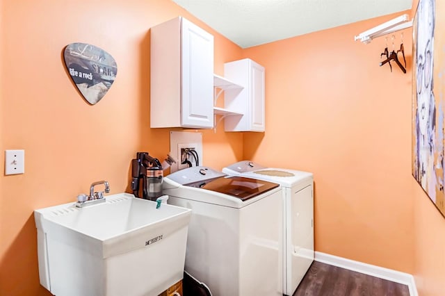 laundry room featuring washer and dryer, dark hardwood / wood-style floors, sink, and cabinets