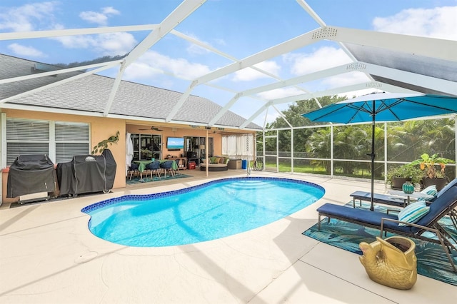 view of pool with ceiling fan, a patio, and a lanai