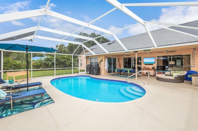 view of swimming pool with a patio, glass enclosure, ceiling fan, and an outdoor hangout area