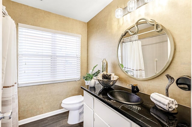 bathroom featuring toilet, hardwood / wood-style flooring, curtained shower, and vanity