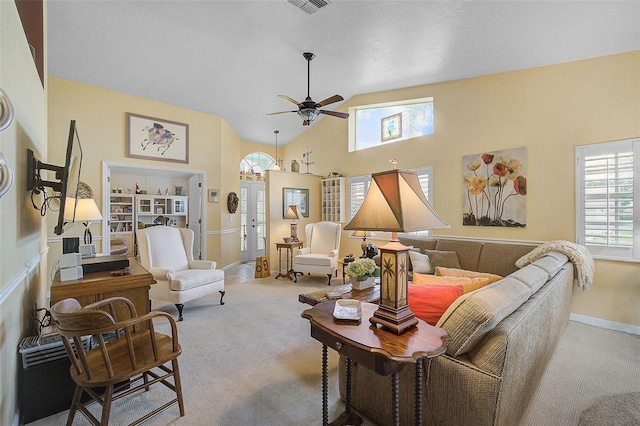 carpeted living room with ceiling fan and high vaulted ceiling