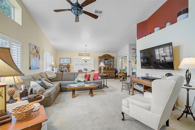 living room with ceiling fan with notable chandelier, light carpet, and plenty of natural light