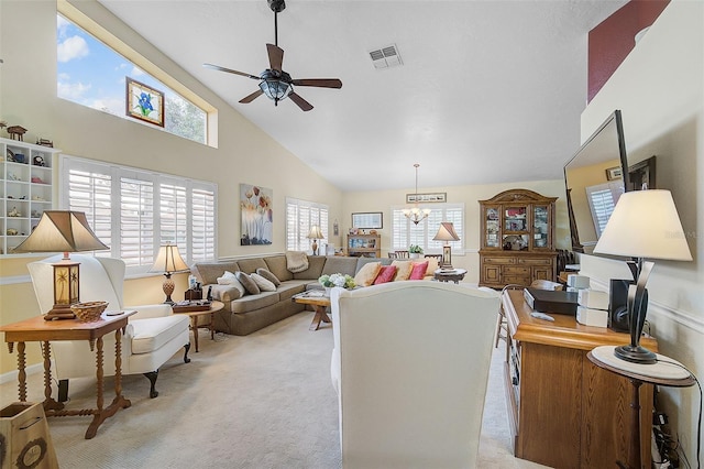 carpeted living room featuring high vaulted ceiling, ceiling fan with notable chandelier, and a healthy amount of sunlight