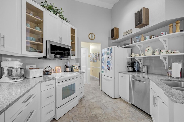 kitchen featuring appliances with stainless steel finishes, backsplash, light tile patterned floors, and white cabinets