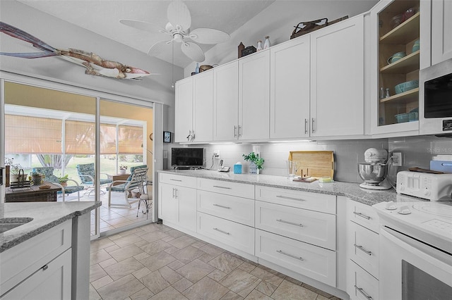 kitchen with white cabinets, backsplash, and light tile patterned flooring