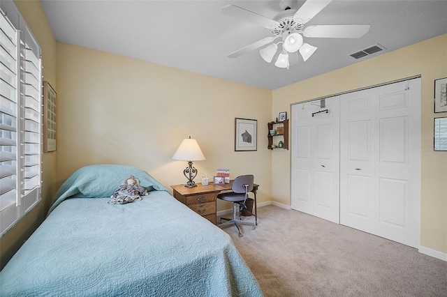 carpeted bedroom with ceiling fan and a closet