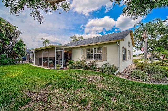 back of property featuring a lawn and a sunroom