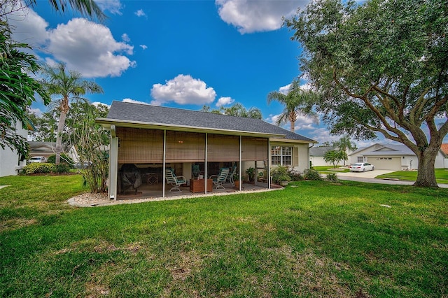 rear view of property with a lawn and a garage