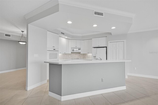 kitchen with decorative backsplash, white cabinets, light tile patterned floors, and white appliances