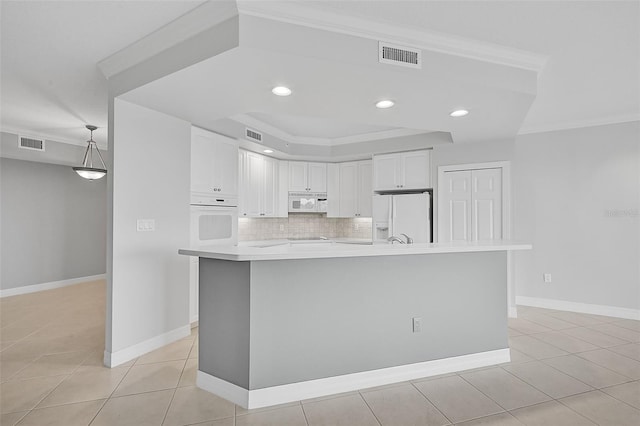 kitchen featuring white cabinetry, white appliances, an island with sink, and decorative backsplash