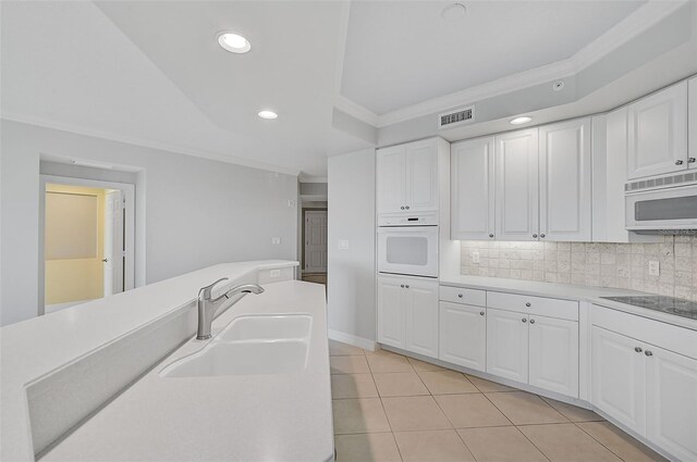 kitchen with sink, white cabinets, white appliances, and decorative backsplash