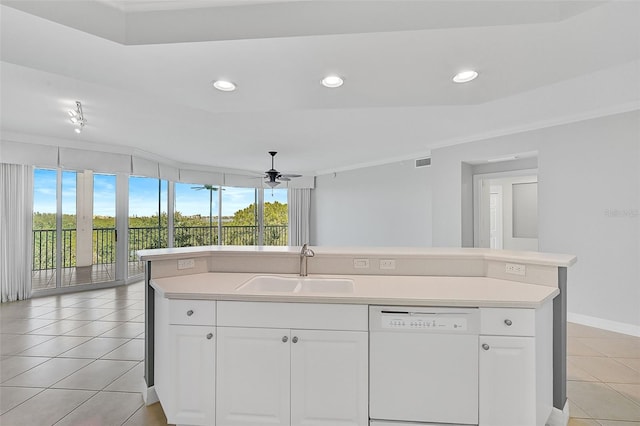 kitchen with dishwasher, sink, white cabinets, light tile patterned floors, and a center island with sink