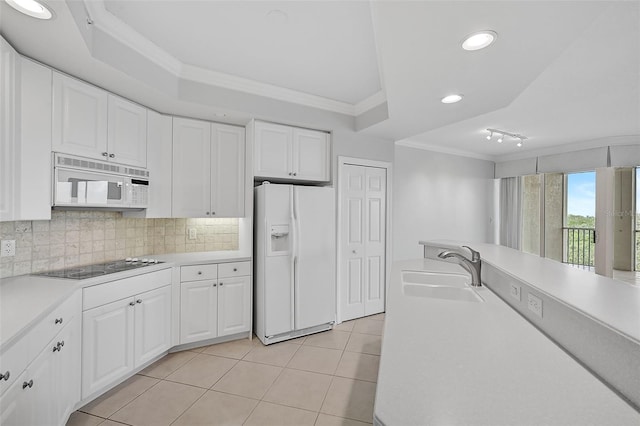 kitchen featuring crown molding, sink, light tile patterned flooring, and white appliances