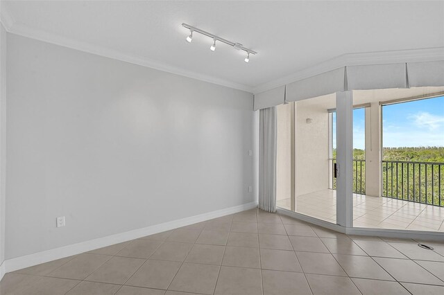 tiled empty room with crown molding and rail lighting