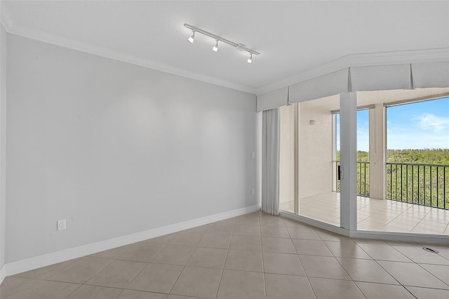 unfurnished room with crown molding, rail lighting, and light tile patterned floors