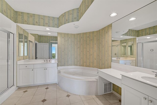 bathroom with double sink vanity, shower with separate bathtub, and tile patterned flooring