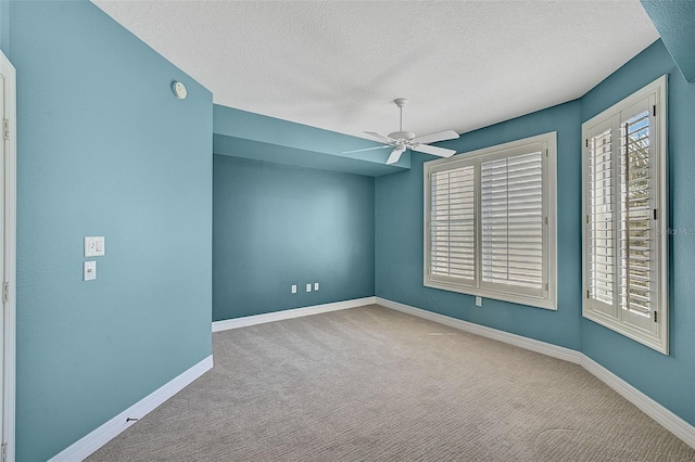 carpeted spare room featuring a textured ceiling and ceiling fan