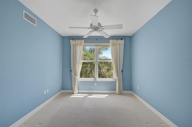 empty room featuring ceiling fan and light carpet