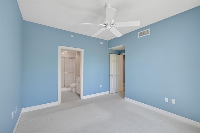 unfurnished bedroom featuring ceiling fan, light colored carpet, and ensuite bathroom