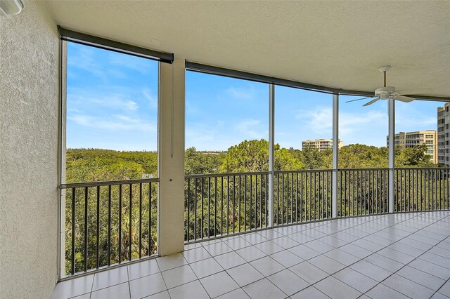 unfurnished sunroom featuring ceiling fan