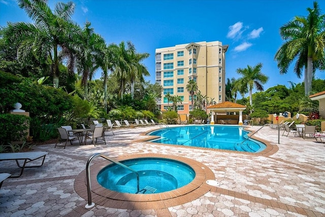 view of swimming pool featuring a community hot tub and a patio area