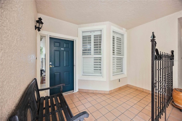 foyer with a textured ceiling and light tile patterned floors